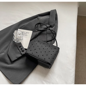 Détail du sac en toile grise à pois avec broderie nœud et base en cuir noir
