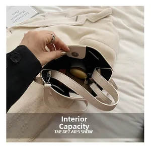 Vue intérieure du sac seau en cuir grainé blanc avec fermoir magnétique et rangement