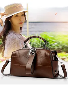 Detail der braunen Vintage-Boston-Tasche aus Leder mit Kieselstruktur und Metallringen