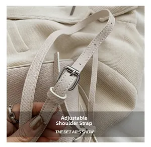 Détail de la bandoulière en cuir beige avec boucle réglable en métal argenté