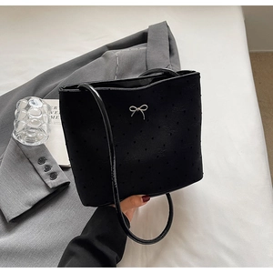 Détail du sac seau noir à pois avec nœud argenté et fine bandoulière en cuir