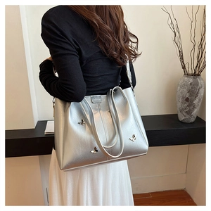 Detailed shot of silver tote bag with 3D butterfly charms and metallic PU leather finish