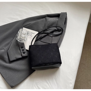 Détail du sac seau noir en toile avec base en cuir et fines bretelles de style minimaliste