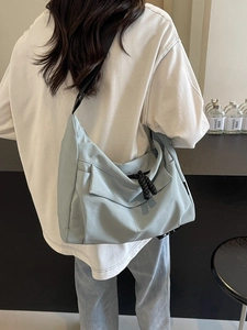 Light blue large capacity canvas crossbody bag with a modern crescent-shaped design