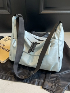 Light blue large capacity nylon crossbody bag with black shoulder strap and zipper detail