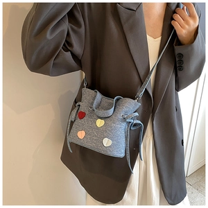 Sac seau bleu clair avec écussons cœurs colorés et détails de fermeture à cordon
