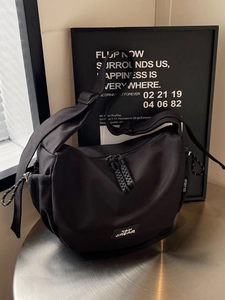 Sac à bandoulière noir minimaliste style dumpling avec double fermeture éclair et logo