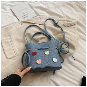 Vue détaillée du sac seau en tissu bleu avec surpiqûres en forme de cœurs colorés en 3D