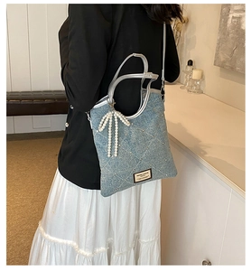 Vue détaillée du sac à main en denim bleu clair avec strass et accessoire noeud en perles