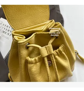 Detail of yellow lychee texture backpack featuring a drawstring opening and magnetic flap