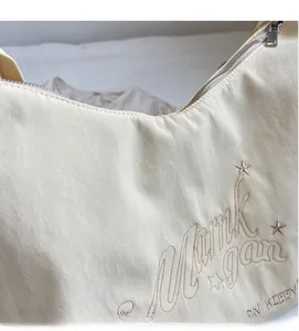 Dettaglio ravvicinato del tessuto in nylon beige con ricamo a stelle e texture morbida