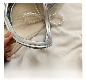 Détail de la poignée du sac en cuir argenté avec coutures de précision et perles