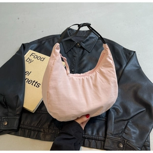 Top view of pale pink nylon crescent bag with adjustable strap and buckle closure