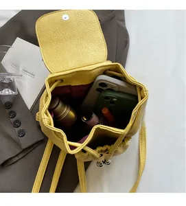 Interior view showing yellow pebble leather backpack capacity for phones and cosmetics