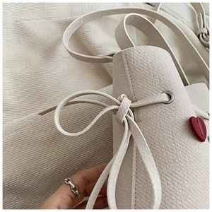 Détail du sac seau en toile avec cœur rouge et fermeture à cordon en nœud