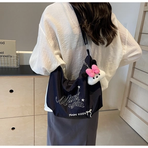 Dettaglio della borsa a tracolla blu navy con stampa e ciondolo di peluche Minnie