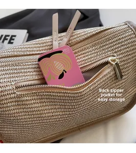 Detail of the rear zipper pocket on a woven beige handbag with leather trim and storage space