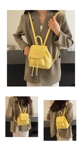 Close-up of vibrant yellow lychee leather backpack showing drawstring and metal beads