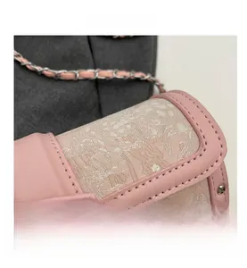 Detail of pink cylinder bag with floral embroidery and silver M-letter metal buckle