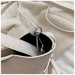 Vue détaillée du sac crème montrant le crochet argenté et la texture cuir litchi