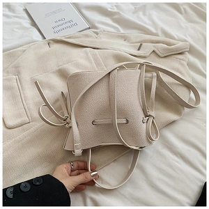 Vue détaillée du sac seau beige avec texture grainée et fermeture par cordon