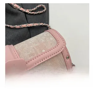 Detail shot of pink floral fabric cylinder bag with silver M lock and chain strap