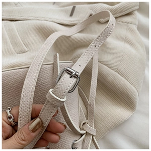 Détail de la bandoulière réglable en cuir crème avec boucle en métal argenté poli du sac