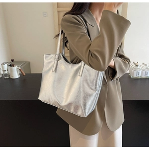 Silver metallic tote bag detail with crinkled leather texture and embossed FUIDEAN logo