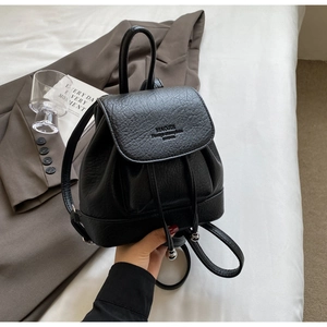 Detail of black pebbled leather mini backpack with drawstring and silver bead accents