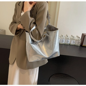 Detail of silver metallic tote bag with crinkled texture on model for summer commuting