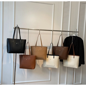 Detail view of minimalist tote bags in six colors hanging on a metal display rack