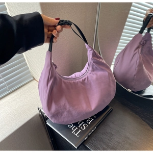 Detail of purple nylon crescent bag with black strap and adjustable buckle closure