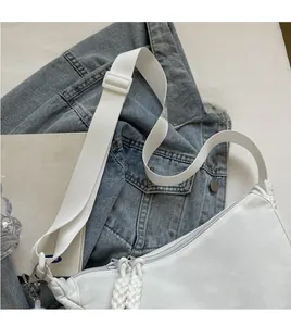 Détail du sac bandoulière en nylon blanc avec broderie aitaotheel et double fermeture