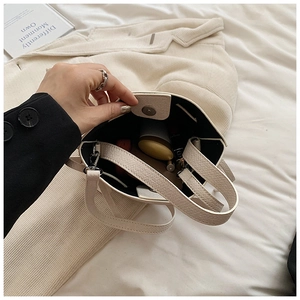 Vue de dessus d'un sac seau crème montrant le grain de cuir et l'intérieur spacieux
