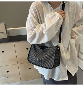 Detailed view of black woven texture shoulder bag with Fashion & Bags logo on a leather trim