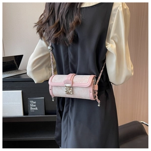 Detail view of pink and white jacquard cylinder bag with silver chain and M buckle