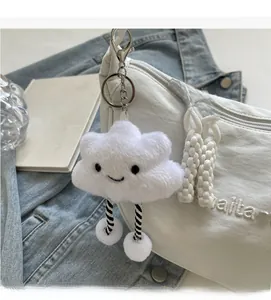 Détail d'un pendentif nuage en peluche blanche avec des jambes rayées sur un sac nylon