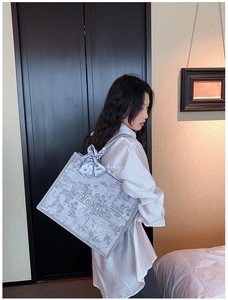 Détail du grand sac cabas gris brodé avec motifs floraux et foulard sur la poignée