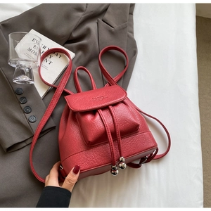 Detail of red pebbled leather mini backpack with drawstring and silver ball hardware