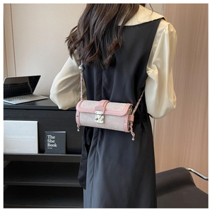 Detailed view of pink and beige cylinder bag with jacquard texture and silver chain strap