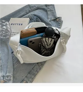 Détail de l'intérieur d'un sac bandoulière en nylon avec tablette et objets essentiels