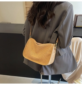 Detail of woven straw crossbody bag with leather trim on model from a back view