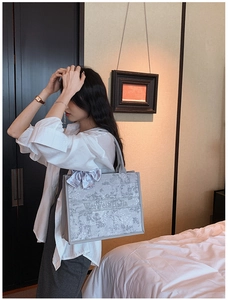 Détail du sac cabas en jacquard gris avec nœud élégant et broderie de luxe