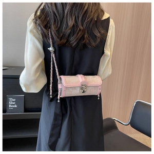 Pink cylindrical crossbody bag with floral lace and silver metal chain on model's back