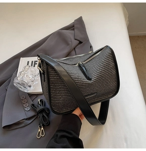 Close-up of woven shoulder bag texture with silver zipper and fashion logo plaque