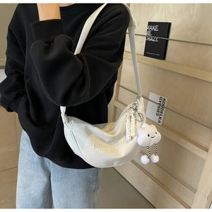 Détail du sac demi-lune en nylon blanc avec broderie et un charmant nuage en peluche