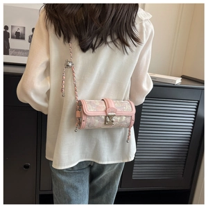 Detail of floral jacquard barrel bag with pink trim, metal chain and M-logo clasp
