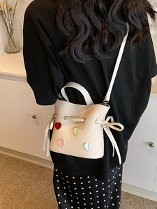 Mini sac seau crème avec cœurs colorés et cordon de serrage, porté de dos par mannequin