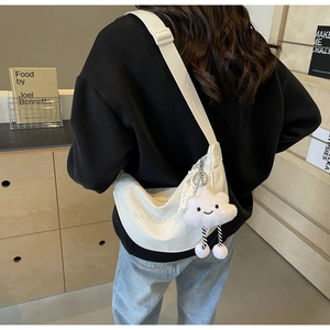 Vue détaillée du sac demi-lune en nylon blanc avec broderie et charme nuage