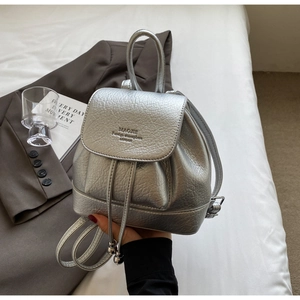 Detailed view of silver backpack featuring lychee grain texture and metal drawstring beads